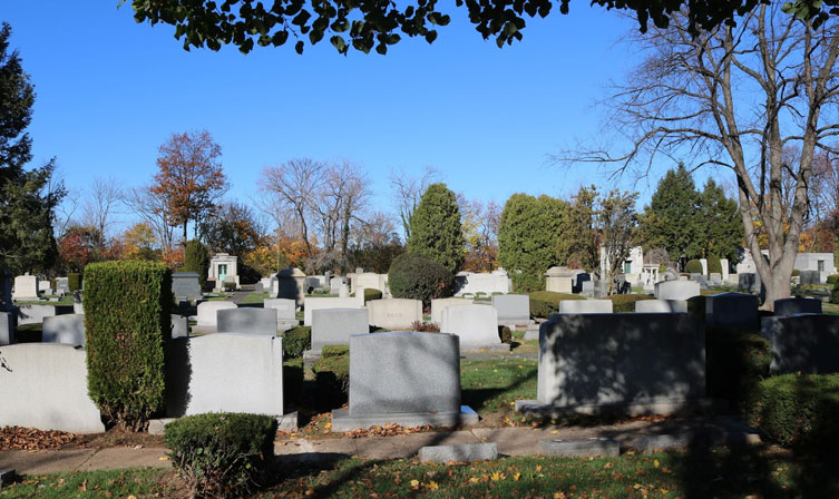 Row of headstones with one tilted